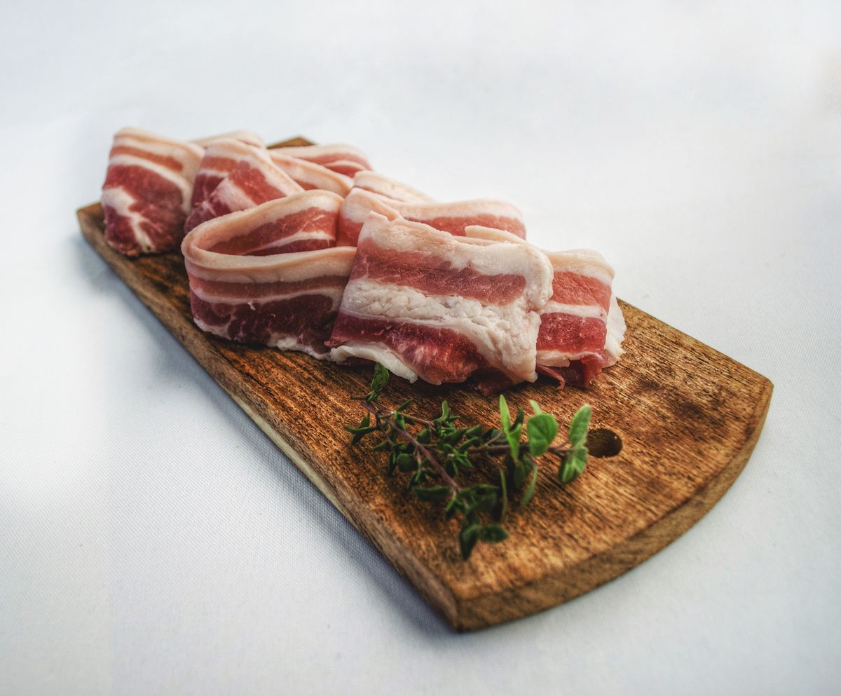 Sliced bacon on a wooden chopping board