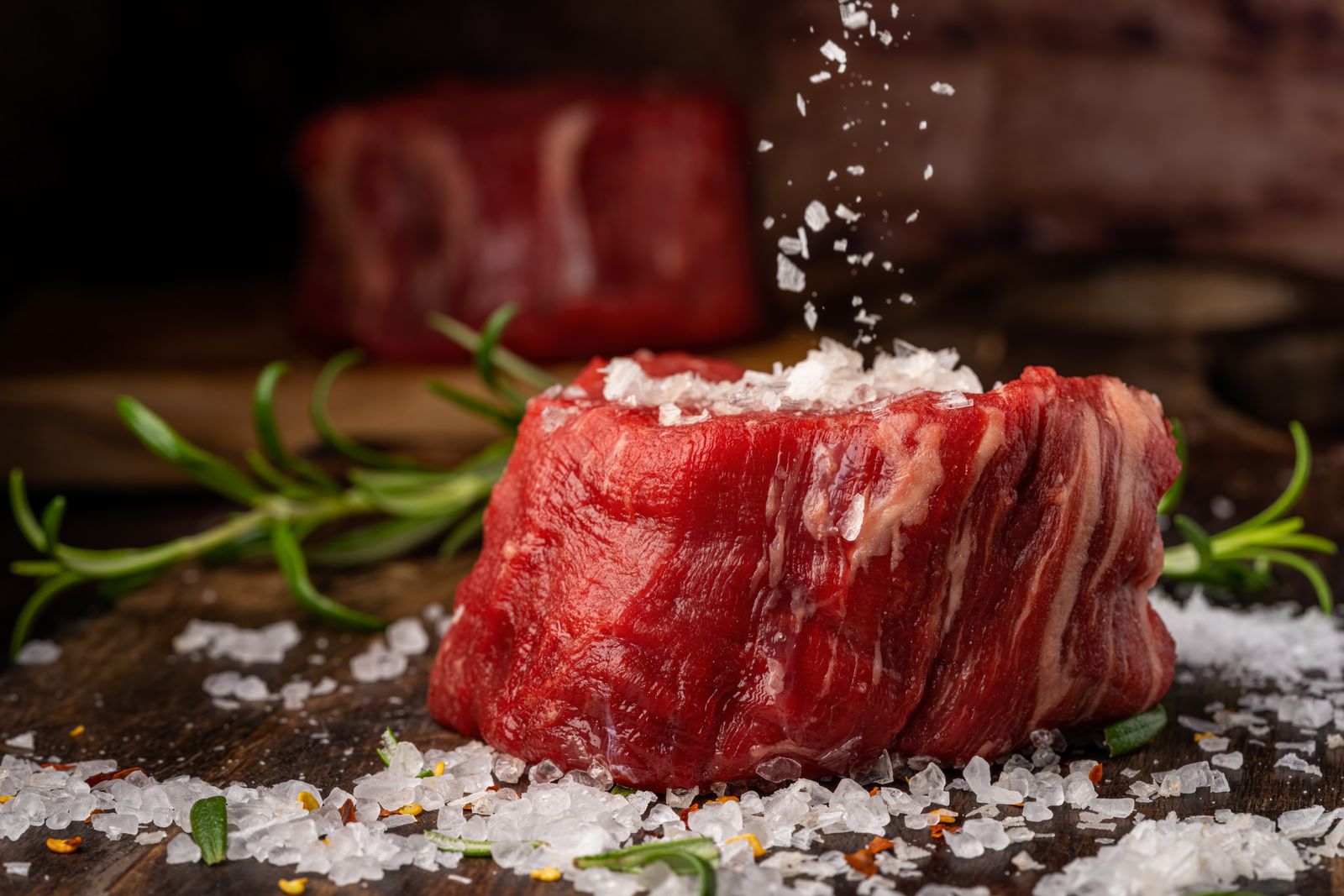 Raw beef steak sprinkled with sea salt and rosemary